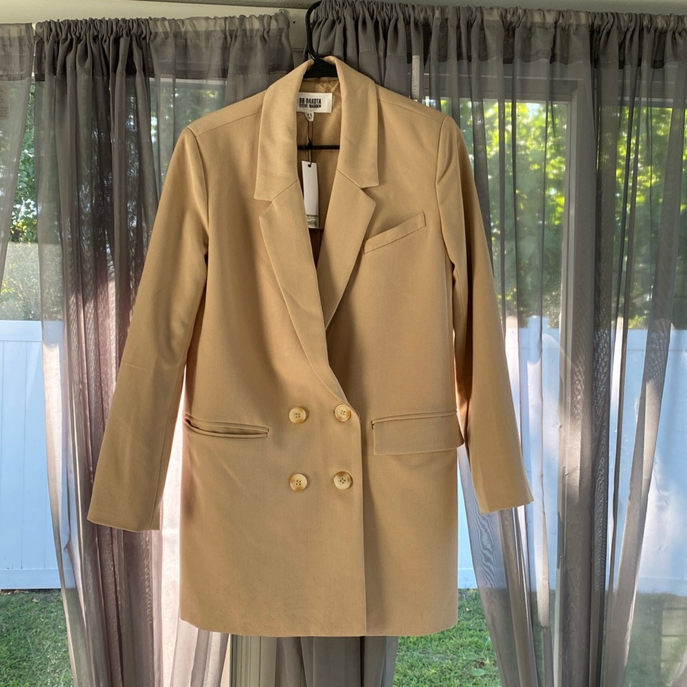 This item is a cream colored double breasted blazer size XS with original tags.